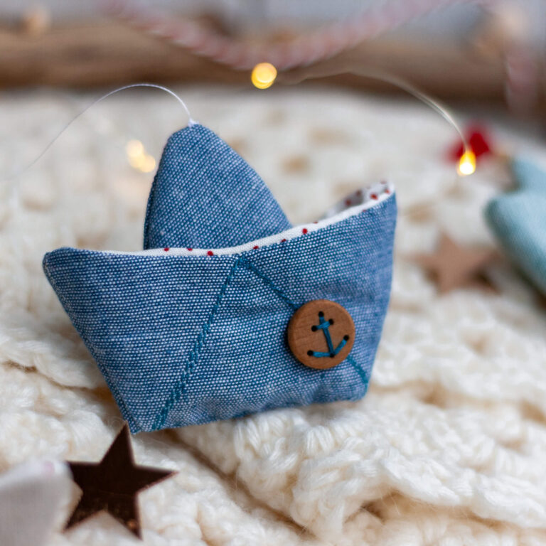 selbst genähtes Schiffchen aus blauem Stoff mit einem Anker-Knopf