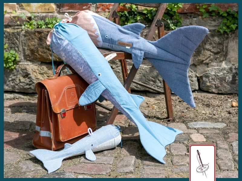 eine Hai-Schultüte und zwei Wal-Schultüten liegen auf einem Stuhl