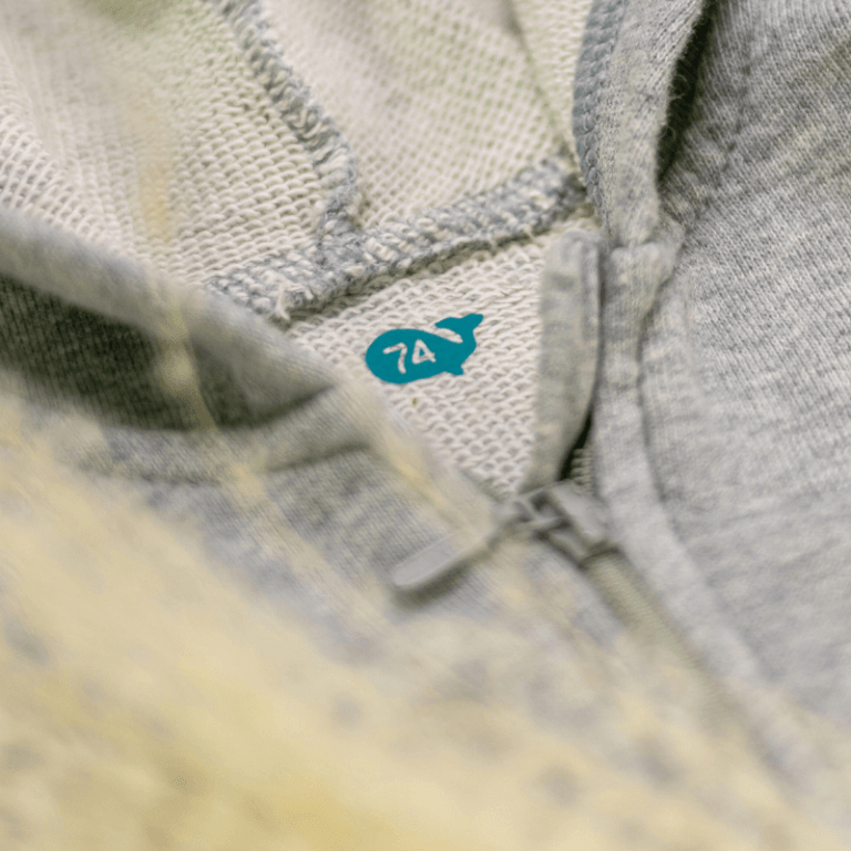 geplottetes Größenlabel Wal in einer Babyjacke