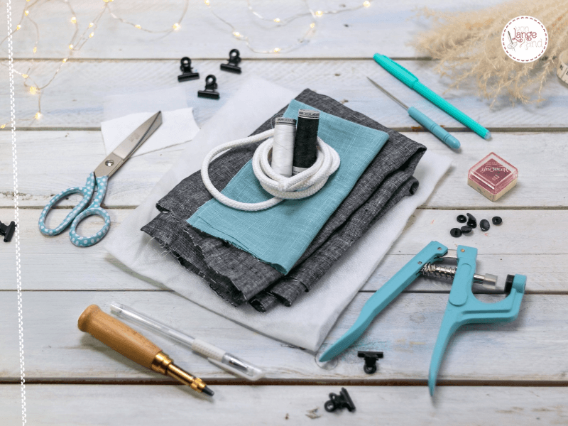 Materialien zum Nähen einer Fledermaus-Wendetasche mit Webstoff, Volumenvlies, Kordel, Druckknöpfen und Karabinern